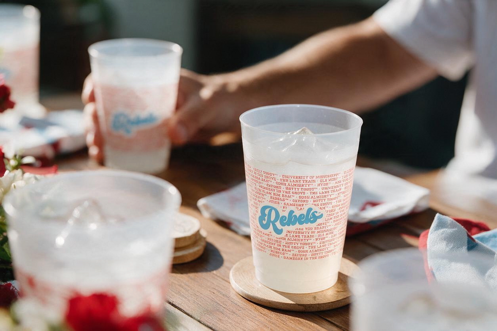 MADdesign Ole Miss Rebels frost flex cups with red team cheers and blue logo on a wooden table at a party